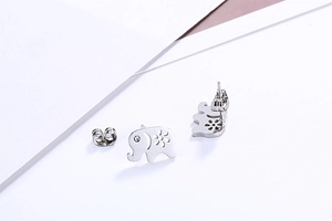 Close-up of silver elephant stud earrings with hollow flower detail and small rhinestones