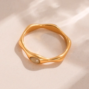 Irregular wavy gold ring featuring an oval rose quartz stone in a minimalist aesthetic