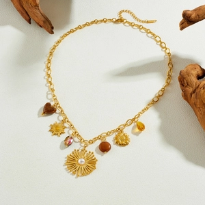Chaîne bohème plaquée or avec cœur en acrylique et pendentifs soleil sur fond en bois