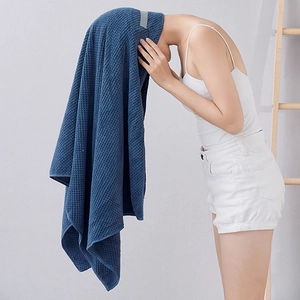 Model wearing dark blue coral fleece hair towel wrap with pineapple waffle texture detail