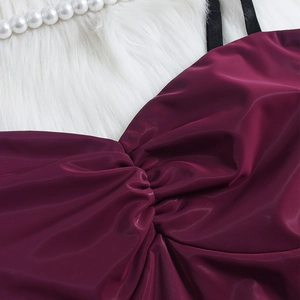 Détail du crop top en satin bordeaux avec fronces sur le buste et fines bretelles