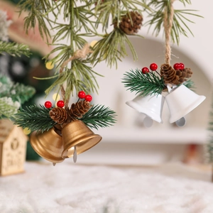 Detail of Christmas metal bells with pine cones, berries and twine for festive hanging decor