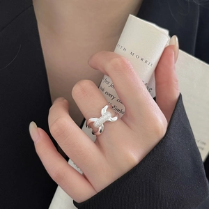 Detail of cross knot 925 sterling silver ring with micro-pave white zircon on finger