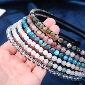 Detail of diverse 6mm natural crystal stone beads on a sleek black handmade headband