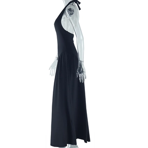 Side view of backless halter maxi dress in black featuring a fluid draped silhouette