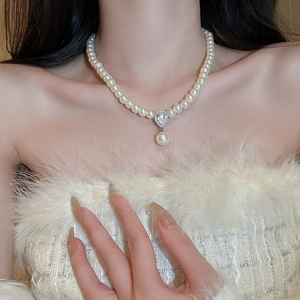 Elegant pearl choker necklace with a zircon teardrop pendant worn by a model