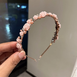 Detail of rose gold headband featuring pink roses, white pearls and sparkling rhinestones