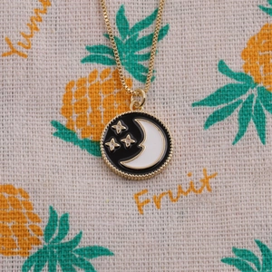 Gold plated moon and star pendant necklace with black and white enamel geometric design