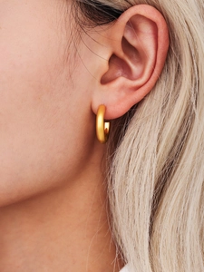 Primer plano de los pendientes de aro en C de acero inoxidable chapados en oro de 18 quilates