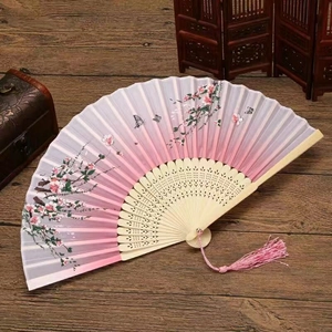 Detail of a Chinese silk folding fan with floral patterns and a pink silk tassel