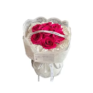 Waterproof white lace net wrap for a bouquet of seven pink roses with golden ribbon