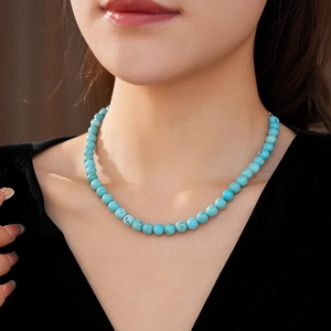 Close-up of minimalist turquoise beaded necklace on neck for a retro elegant look