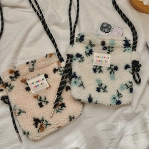Dettaglio di mini borse floreali in peluche con tracolla intrecciata e vano cellulare