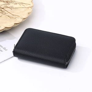 Detail of black pebbled leather card holder with secure metal zipper closure on white background