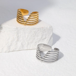 Detailed shot of gold and silver multi-layer geometric rings on a white stone base
