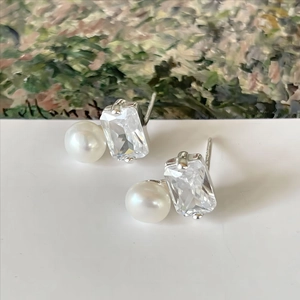 925 silver stud earrings with square-cut crystal and pearl on artistic background