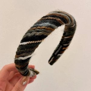 Detail of colorful hand-knitted headband showing texture and hand made label