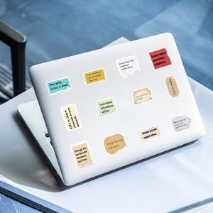 Inspirational torn paper style stickers featuring English quotes on a laptop cover