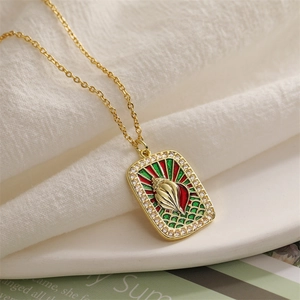 Macro detail of gold tarot pendant with shell motif and colorful enamel inlay