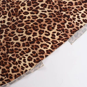 Close-up detail of leopard print fabric with precise overlock stitching on the hem