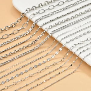 Detail of silver Y2K steel chains including O-link and Figaro styles on white tray