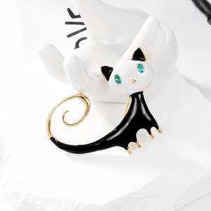 Cute black and white cat brooch with golden accents and green eyes on white background