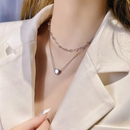 Close-up of elegant double-layered silver necklace with heart pendant on model