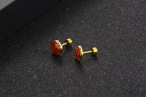 Macro shot of gold plated rose stud earrings with red enamel and secure screw backs