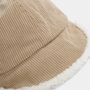 Close-up of corduroy fisherman hat featuring soft white sherpa fleece trim and texture