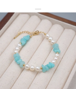 Gros plan d'un bracelet en perles et pierres bleues sur un écrin en velours blanc