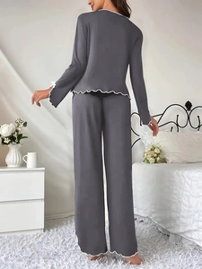 Detail of grey pajama set featuring delicate white lettuce trim and soft jersey fabric