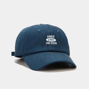 Dettaglio del cappellino in cotone blu navy con ricamo bianco 'Since 1987'
