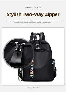 Close-up of durable metal two-way zippers and colorful letter strap on black backpack