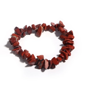 Close-up of natural red jasper chip stone bracelet with organic textures on white base