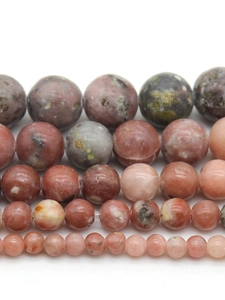 Close-up of plum blossom jade stone beads in various sizes with natural spotted textures