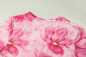 Gros plan du haut en maille imprimé floral rose montrant l'encolure et la texture