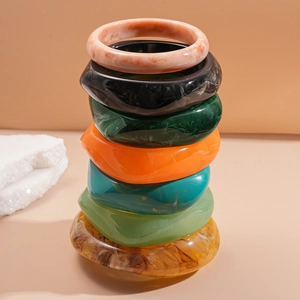 Set of 7 colorful marbled resin bangles in square and oval shapes for a modern retro look