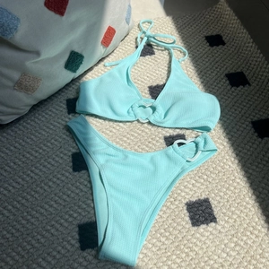 Detail of mint green bikini with heart buckles and textured seersucker fabric finish
