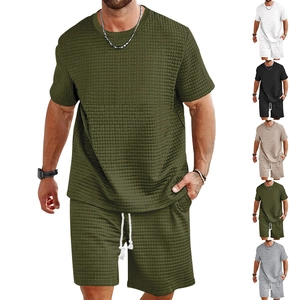 Detailed macro view of waffle texture fabric on men's army green summer t-shirt and shorts set