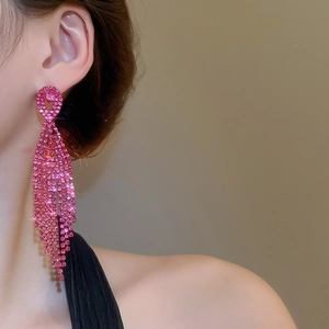 Close-up of sparkling rose pink rhinestone tassel earrings hanging elegantly on a model