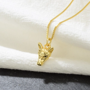 Detail of 18k gold plated wolf head pendant necklace with micro-inlaid zircon stones