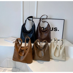Group display of chic hobo bags in black, brown, and beige on minimalist tiered stands