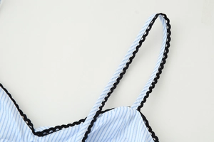 Detail eines blau-weiß gestreiften Kleides mit schwarzer Spitze an den Trägern