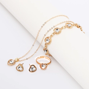 Detailed view of gold heart jewelry set with necklace, bracelet, ring and earrings