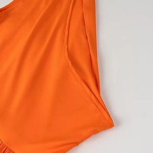 Gros plan du tissu élastique orange avec des coutures de haute qualité sur la robe élégante