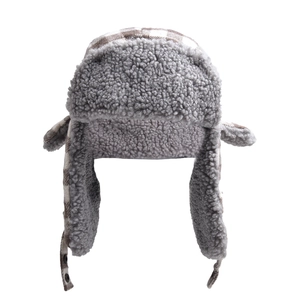 Detail of winter trapper hat with brown checkered pattern and grey fleece lining