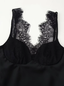 Close-up of black satin camisole with delicate eyelash lace trim and V-neck detail