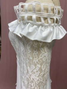 Dettaglio abito da sposa pizzo bianco sporco con volant e ricami floreali intricati
