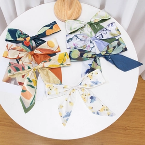 Silk-like ribbon scrunchies with various floral and citrus prints on a white table
