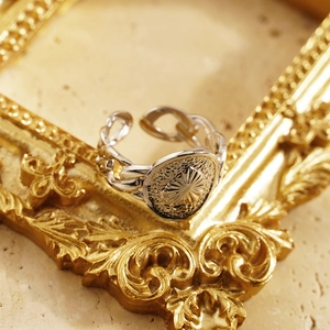 Vintage silver heart Cuban chain ring with sun relief pattern on marble surface